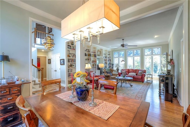 12409 Cambridge Cir, Leawood, KS 66209 - dining room featuring ornamental molding, wood finished floors, a ceiling fan, stairs, and built in features