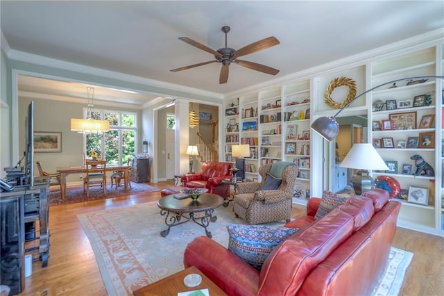 12409 Cambridge Cir, Leawood, KS 66209 - living area with ornamental molding, ceiling fan, wood finished floors, built in features, and a chandelier