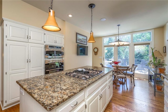 12409 Cambridge Cir, Leawood, KS 66209 - kitchen featuring stainless steel gas cooktop, stone countertops, a chandelier, light wood-type flooring, and white cabinetry