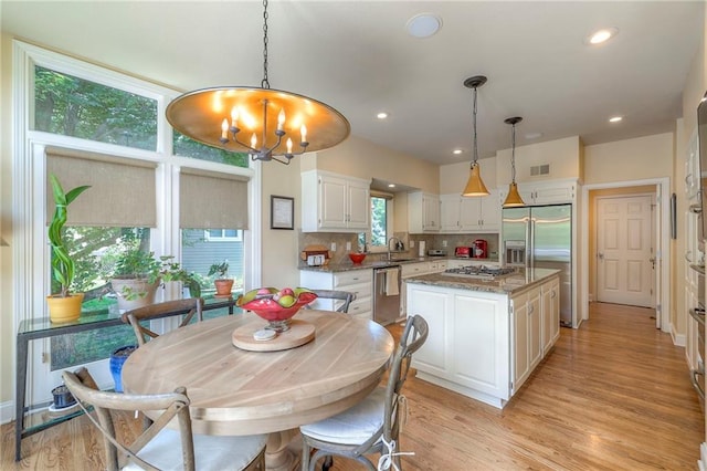 12409 Cambridge Cir, Leawood, KS 66209 - dining area featuring a chandelier, light wood-style flooring, and recessed lighting