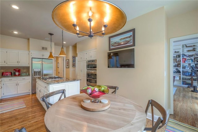 12409 Cambridge Cir, Leawood, KS 66209 - dining room with light wood-style flooring, a chandelier, and recessed lighting