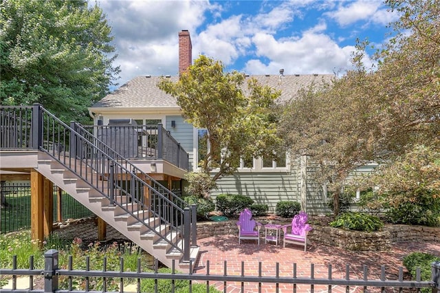 12409 Cambridge Cir, Leawood, KS 66209 - rear view of house with stairway, a patio area, a chimney, a wooden deck, and roof with shingles