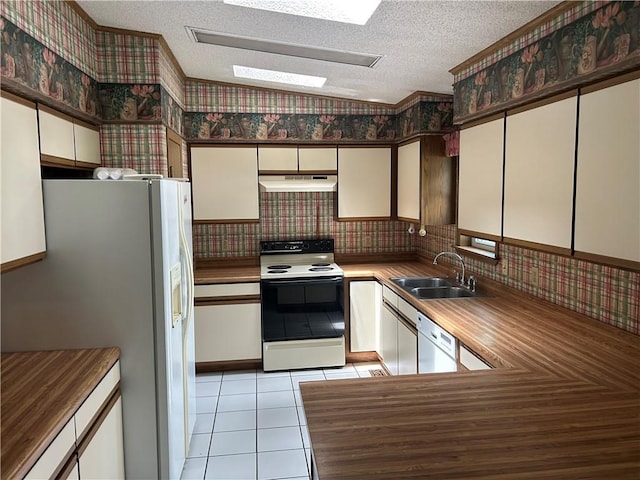 34908 E Shores Rd, Lone Jack, MO 64070 - kitchen featuring white appliances, under cabinet range hood, wallpapered walls, a textured ceiling, and light tile patterned floors