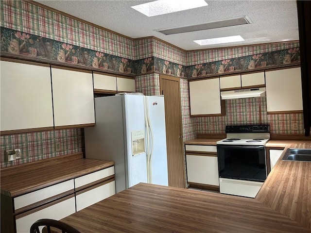 34908 E Shores Rd, Lone Jack, MO 64070 - kitchen with white appliances, under cabinet range hood, a textured ceiling, wallpapered walls, and white cabinetry