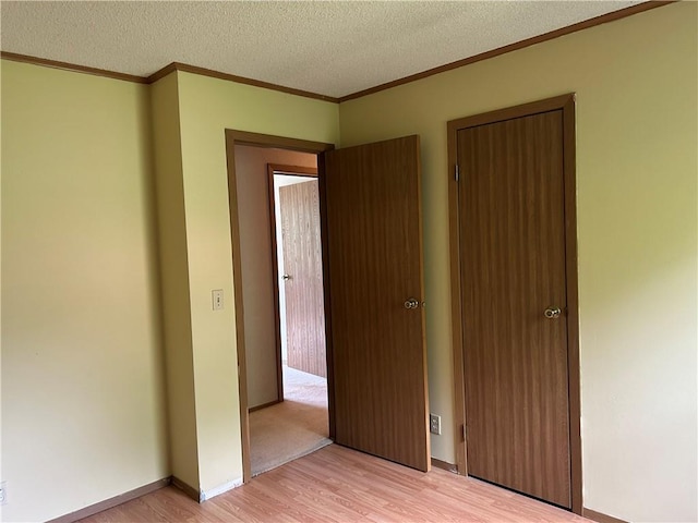 34908 E Shores Rd, Lone Jack, MO 64070 - unfurnished bedroom with light wood-type flooring, crown molding, and a textured ceiling