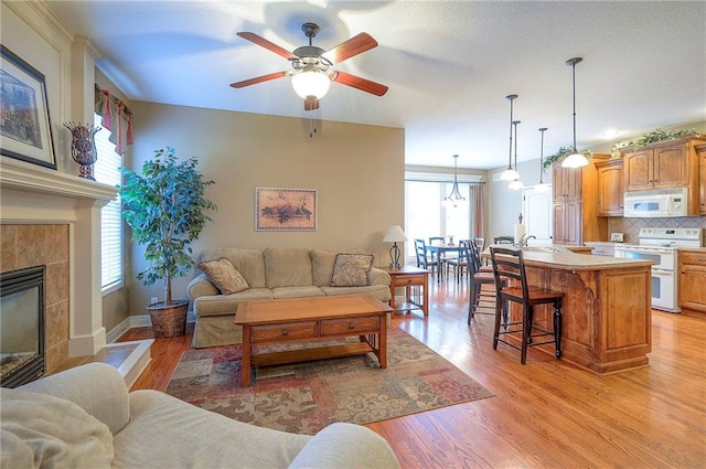 1105 Blazing Star Dr, Lees Summit, MO 64081 - living area with ceiling fan, light wood-style floors, and a fireplace
