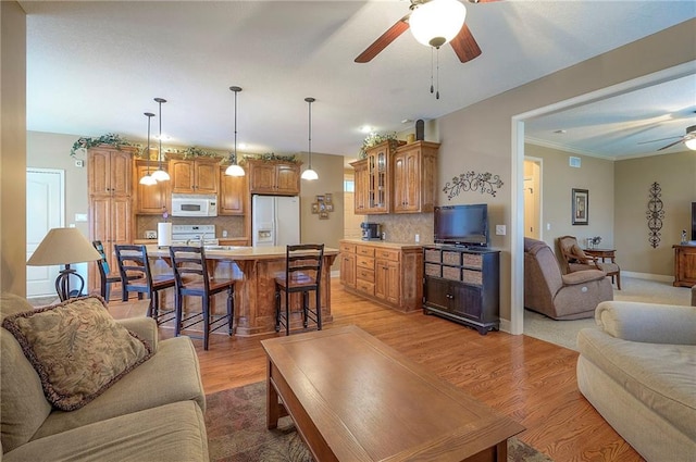 1105 Blazing Star Dr, Lees Summit, MO 64081 - living area featuring ceiling fan, light wood finished floors, and ornamental molding