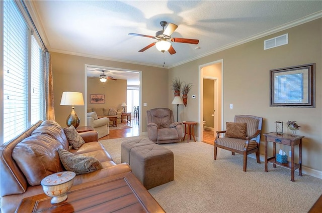 1105 Blazing Star Dr, Lees Summit, MO 64081 - carpeted living area featuring a ceiling fan, plenty of natural light, and crown molding