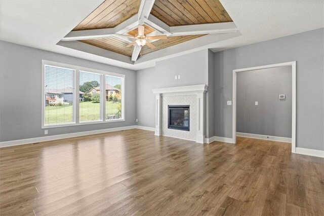 12421 Meadow Ln, Kansas City, KS 66109 - unfurnished living room with wood finished floors, ceiling fan, a tile fireplace, a raised ceiling, and coffered ceiling
