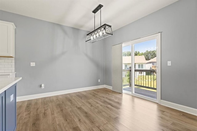 12421 Meadow Ln, Kansas City, KS 66109 - unfurnished dining area featuring wood finished floors and a chandelier