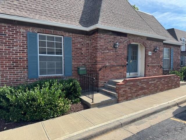 5737 Metcalf Ct, Overland Park, KS 66202 - doorway to property featuring roof with shingles and brick siding