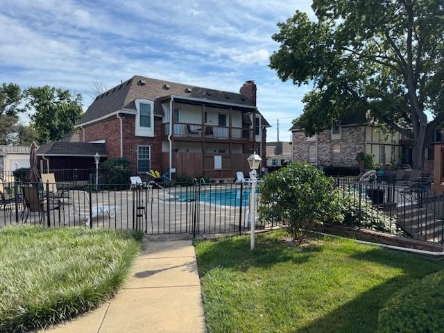 5737 Metcalf Ct, Overland Park, KS 66202 - exterior space with a chimney, a community pool, and brick siding