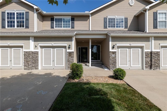 632 SW Shadow Glen Ct, Blue Springs, MO 64015 - townhome / multi-family property featuring a garage, stone siding, driveway, and stucco siding