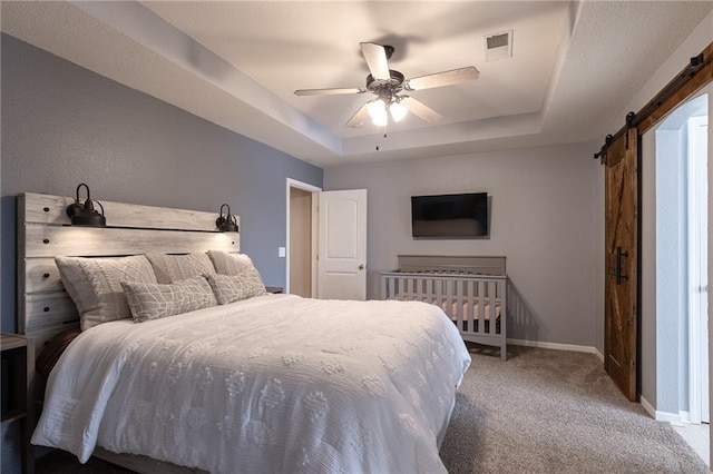 632 SW Shadow Glen Ct, Blue Springs, MO 64015 - bedroom with a barn door, a tray ceiling, carpet, and a ceiling fan