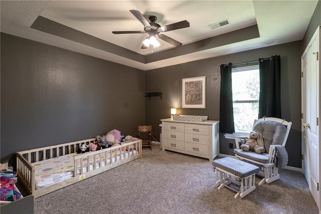 632 SW Shadow Glen Ct, Blue Springs, MO 64015 - bedroom with a tray ceiling, carpet floors, a crib, and a ceiling fan