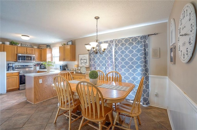 17470 S Walter St, Gardner, KS 66030 - dining space with a chandelier, a textured ceiling, a wainscoted wall, and tile patterned floors