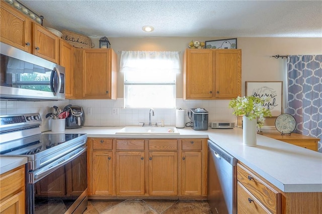 17470 S Walter St, Gardner, KS 66030 - kitchen featuring appliances with stainless steel finishes, a peninsula, light countertops, backsplash, and a textured ceiling