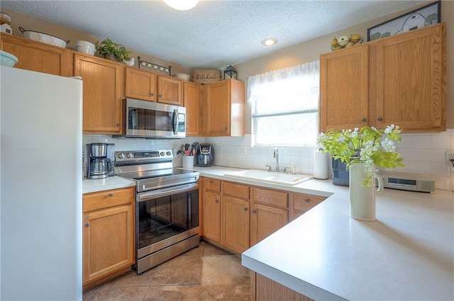17470 S Walter St, Gardner, KS 66030 - kitchen featuring stainless steel appliances, decorative backsplash, light countertops, and a textured ceiling