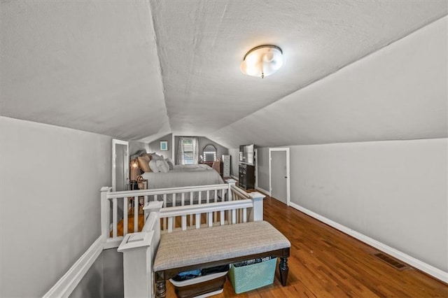 1115 W 26th St S, Independence, MO 64052 - bedroom featuring wood finished floors, a textured ceiling, and vaulted ceiling