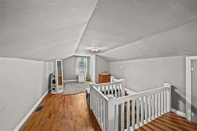 1115 W 26th St S, Independence, MO 64052 - bedroom featuring a textured ceiling, wood finished floors, lofted ceiling, and a crib