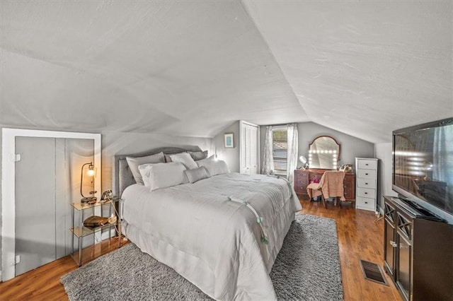 1115 W 26th St S, Independence, MO 64052 - bedroom with lofted ceiling, wood finished floors, and a textured ceiling