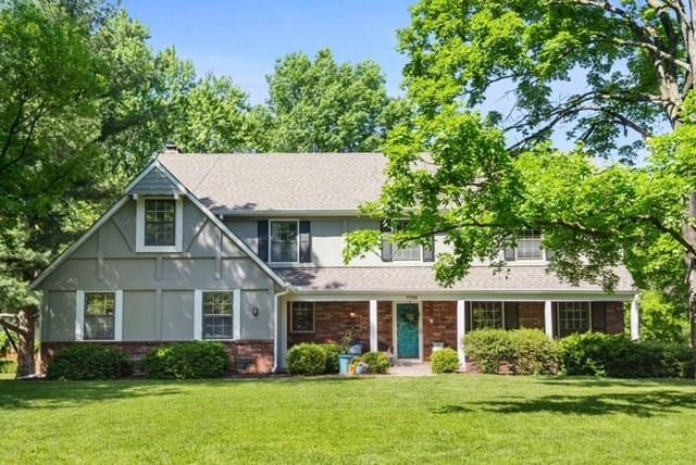 7710 Noland Rd, Lenexa, KS 66216 - tudor house featuring a front yard and brick siding