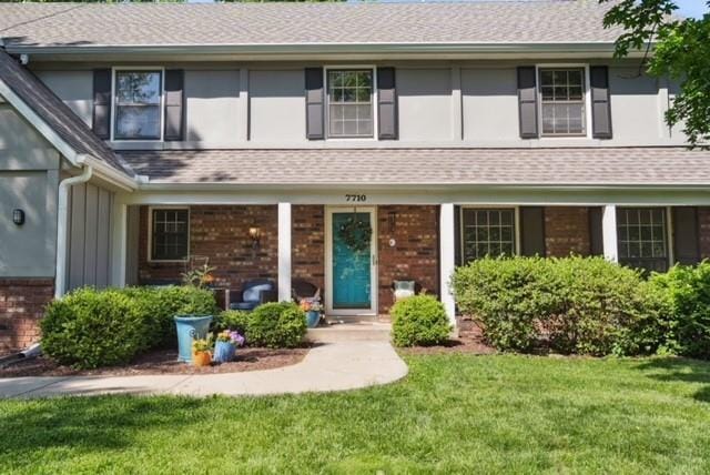 7710 Noland Rd, Lenexa, KS 66216 - view of front of home featuring brick siding, a front lawn, and a shingled roof