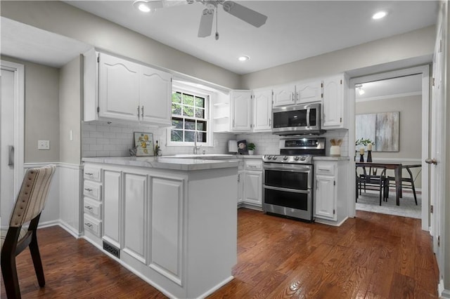 7710 Noland Rd, Lenexa, KS 66216 - kitchen featuring stainless steel appliances, white cabinets, a ceiling fan, light countertops, and a peninsula