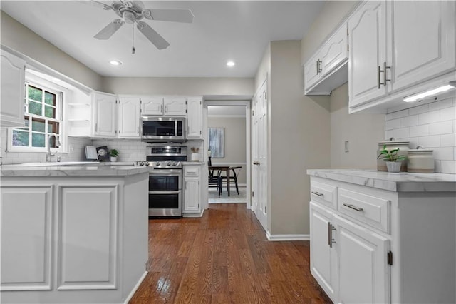 7710 Noland Rd, Lenexa, KS 66216 - kitchen featuring stainless steel appliances, decorative backsplash, white cabinets, light countertops, and recessed lighting