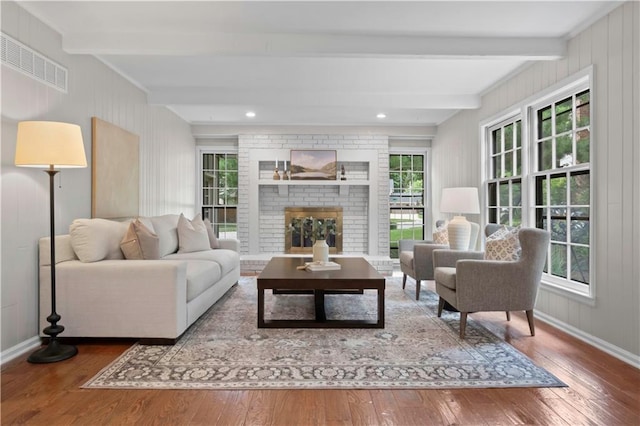 7710 Noland Rd, Lenexa, KS 66216 - living room featuring hardwood / wood-style flooring, beamed ceiling, and a brick fireplace