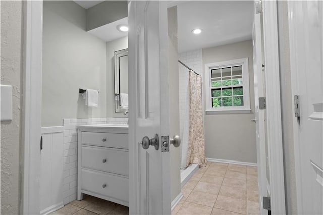 7710 Noland Rd, Lenexa, KS 66216 - full bathroom with vanity, tile patterned flooring, a shower with shower curtain, and wainscoting