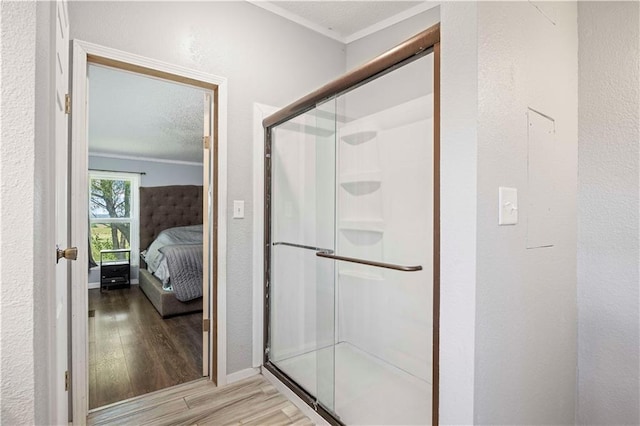 679 Kingman Rd, Pomona, KS 66076 - full bathroom featuring wood finished floors, crown molding, a shower stall, ensuite bathroom, and a textured wall