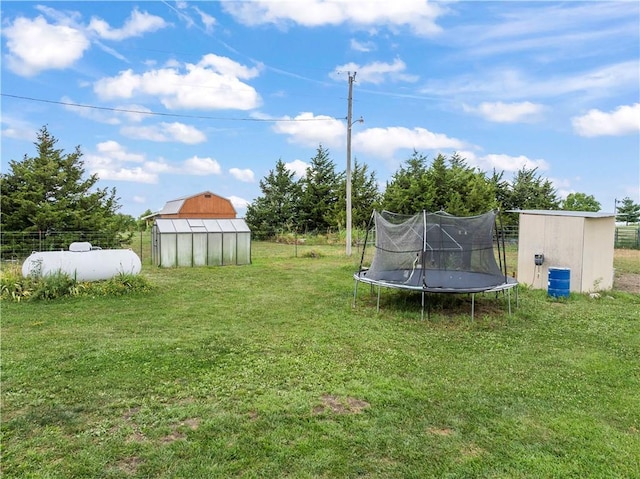 679 Kingman Rd, Pomona, KS 66076 - view of yard with a trampoline, an outdoor structure, and a greenhouse