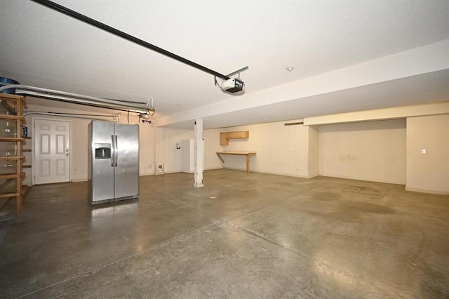12905 Ridgeview Dr, Platte City, MO 64079 - garage featuring stainless steel fridge with ice dispenser and a garage door opener