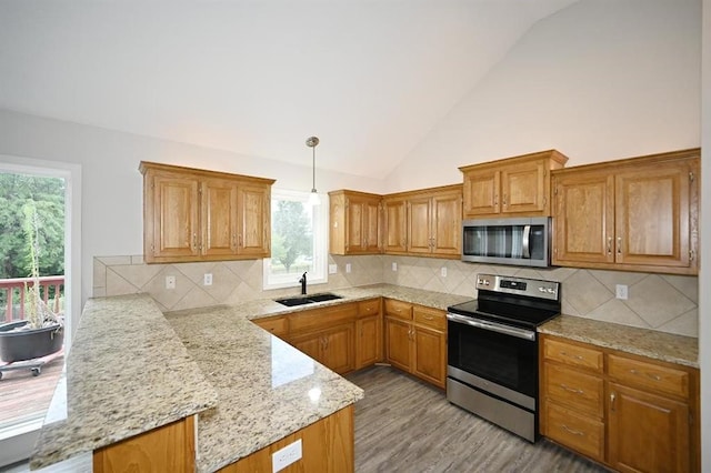 12905 Ridgeview Dr, Platte City, MO 64079 - kitchen with stainless steel appliances, a peninsula, lofted ceiling, healthy amount of natural light, and light wood-style floors