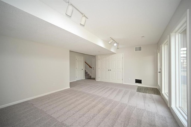 12905 Ridgeview Dr, Platte City, MO 64079 - unfurnished living room featuring track lighting, stairs, and carpet