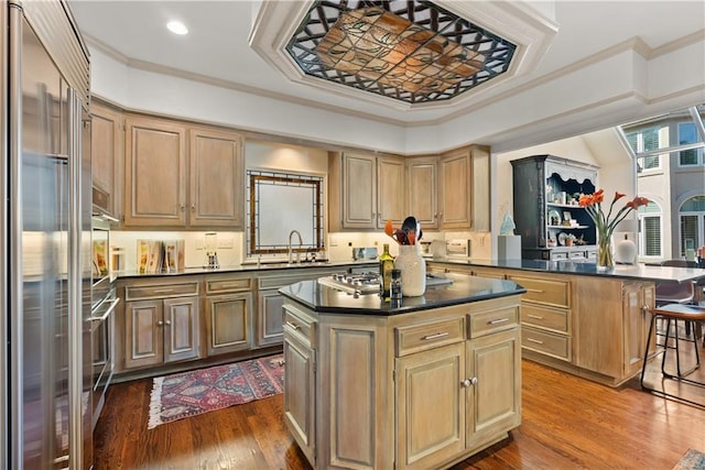 5212 W 98th Ter, Overland Park, KS 66207 - kitchen with appliances with stainless steel finishes, ornamental molding, a peninsula, dark countertops, and a center island