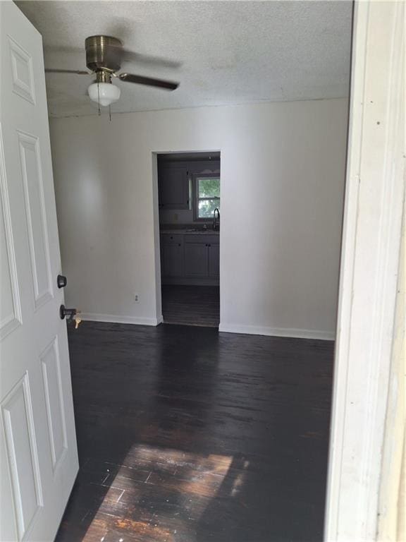 608 N Cedar St, Ottawa, KS 66067 - empty room featuring dark wood finished floors, a textured ceiling, and a ceiling fan
