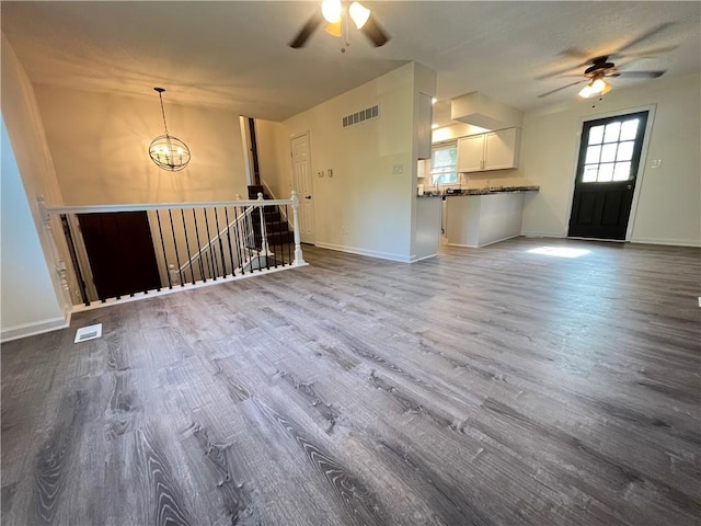 14948 Lakeside Dr, Excelsior Springs, MO 64024 - unfurnished living room featuring ceiling fan, dark wood-style flooring, and a chandelier