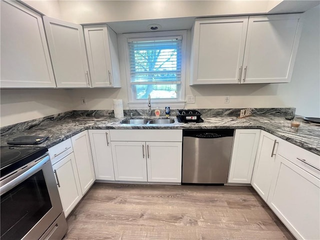 14948 Lakeside Dr, Excelsior Springs, MO 64024 - kitchen with appliances with stainless steel finishes, light wood-style floors, dark stone counters, and white cabinets