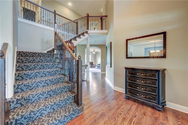 10963 S Carbondale St, Olathe, KS 66061 - stairs featuring wood finished floors, a high ceiling, and a chandelier