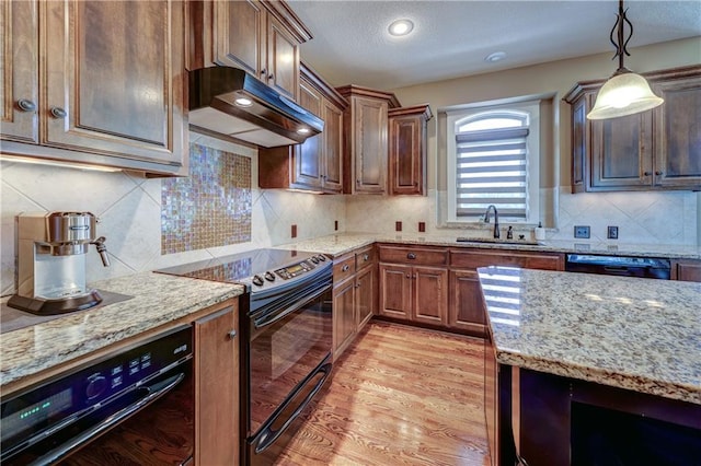 10963 S Carbondale St, Olathe, KS 66061 - kitchen featuring black appliances, under cabinet range hood, light stone countertops, hanging light fixtures, and backsplash