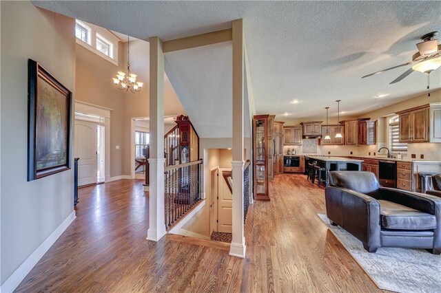10963 S Carbondale St, Olathe, KS 66061 - living area featuring plenty of natural light, light wood finished floors, a chandelier, ceiling fan, and a textured ceiling