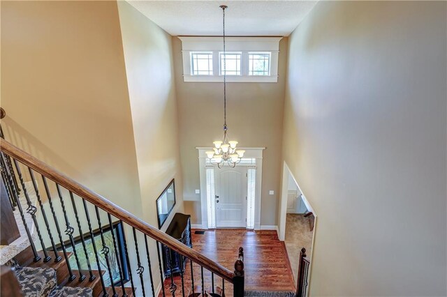 10963 S Carbondale St, Olathe, KS 66061 - foyer entrance with a chandelier, stairway, wood finished floors, and a high ceiling