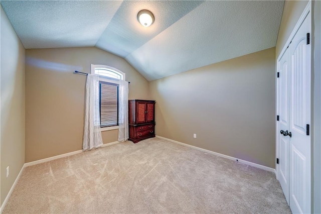 10963 S Carbondale St, Olathe, KS 66061 - additional living space with carpet floors, lofted ceiling, and a textured ceiling
