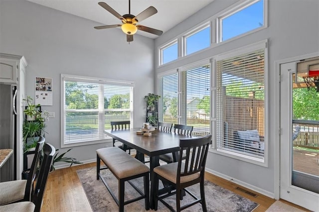 2312 SW Post Oak Ct, Lees Summit, MO 64082 - dining room with a high ceiling, a ceiling fan, and light wood-style floors