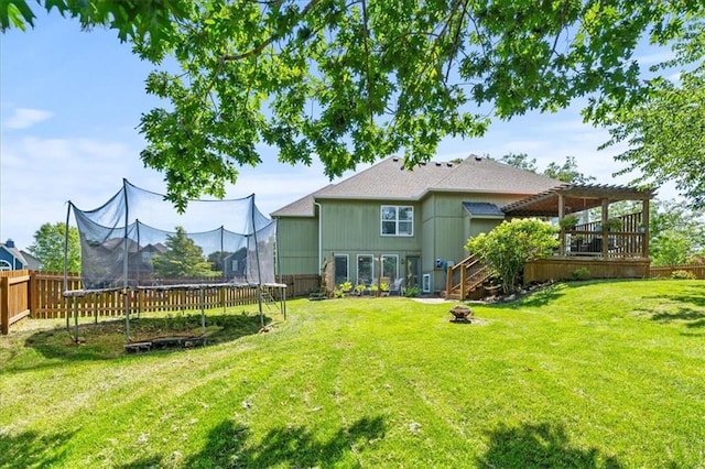 2312 SW Post Oak Ct, Lees Summit, MO 64082 - back of house featuring a trampoline, a fenced backyard, a fire pit, a wooden deck, and a pergola