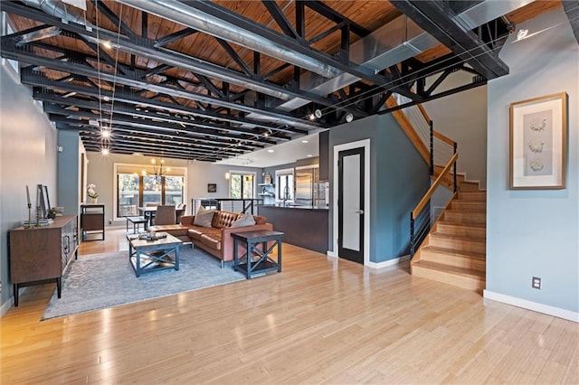 1303 W 47th St, Kansas City, MO 64112 - living area featuring wood finished floors, stairs, and a chandelier