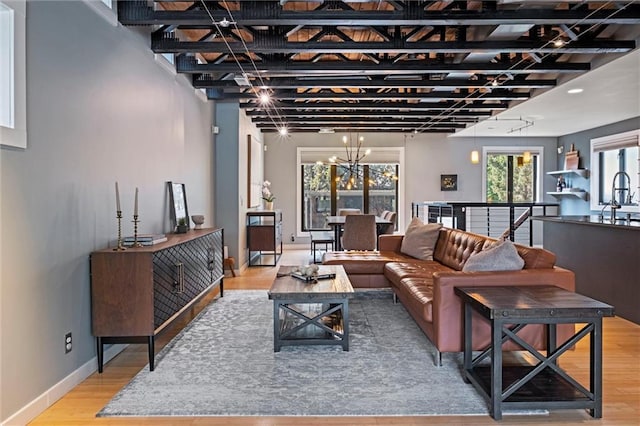 1303 W 47th St, Kansas City, MO 64112 - living room featuring plenty of natural light, wood finished floors, and a chandelier