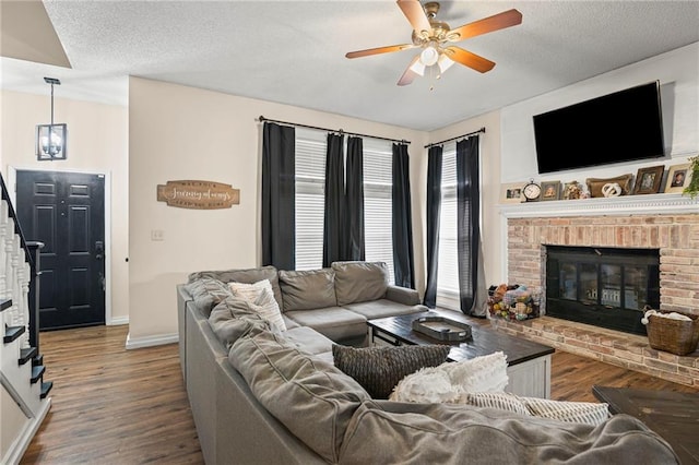 17507 E 35th Ter, Independence, MO 64055 - living room with a brick fireplace, ceiling fan, wood finished floors, stairs, and a textured ceiling